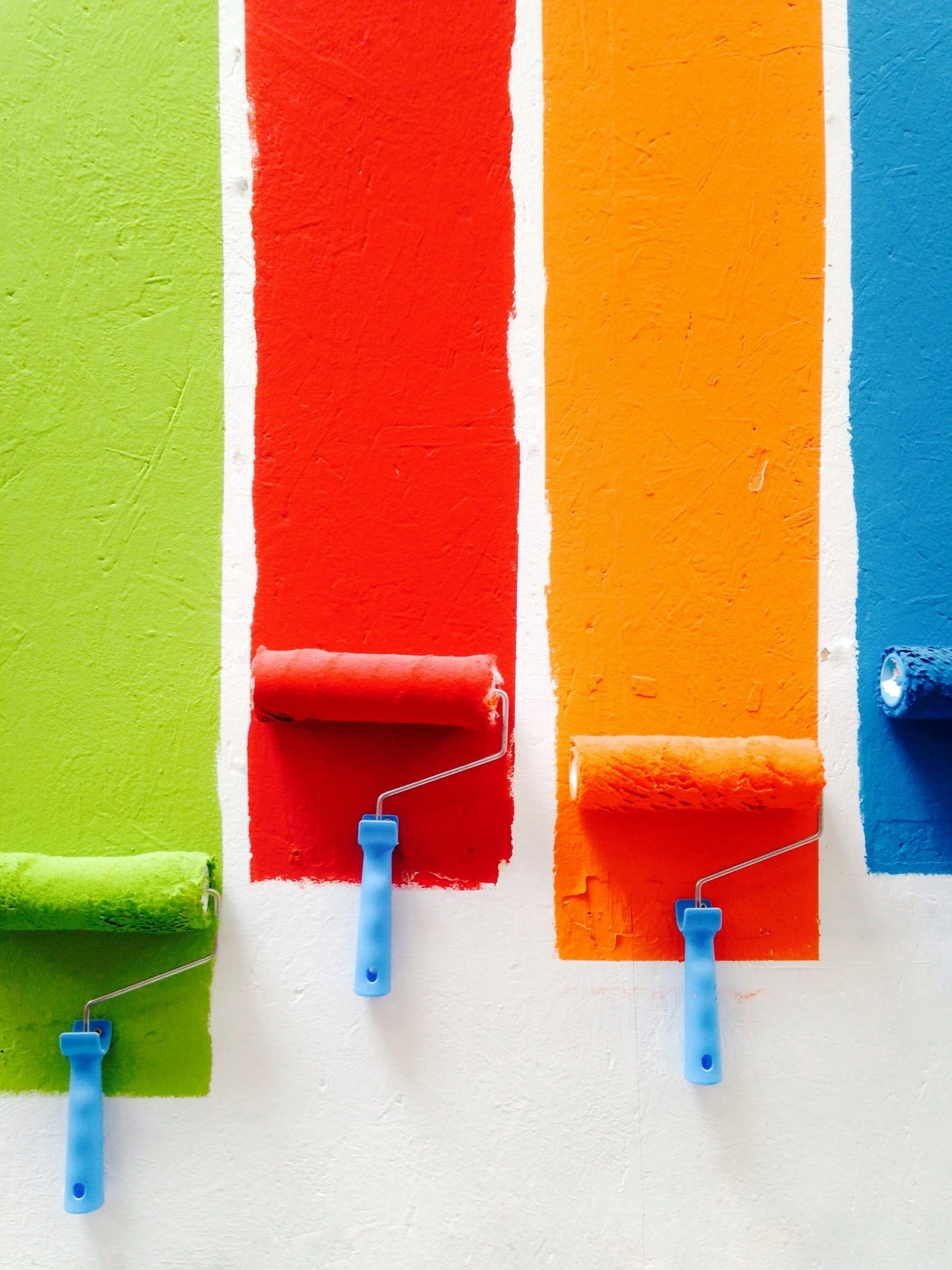 4 different paint brushes, 1 green, 1 red, 1 orange, 1 blue