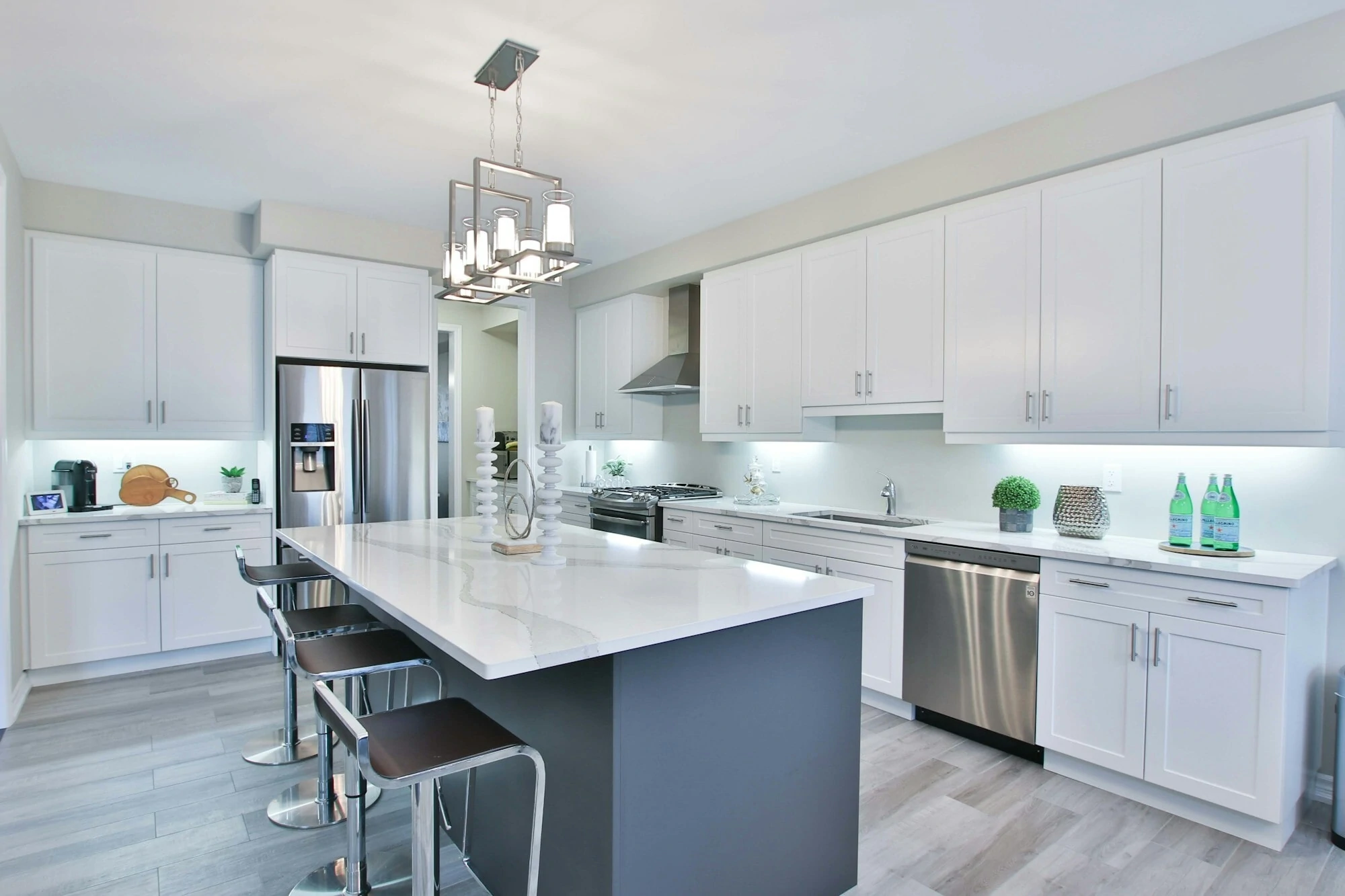 modern kitchen with white cupboards and counter tops, grey hardwood floors