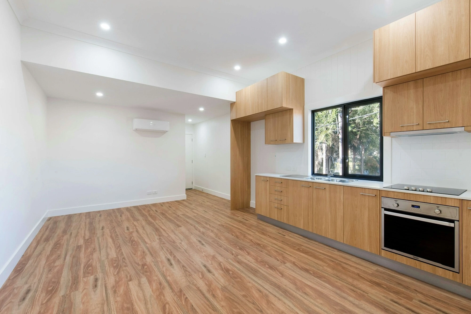 Empty modern home, freshly painted white walls with brown wooden floor.